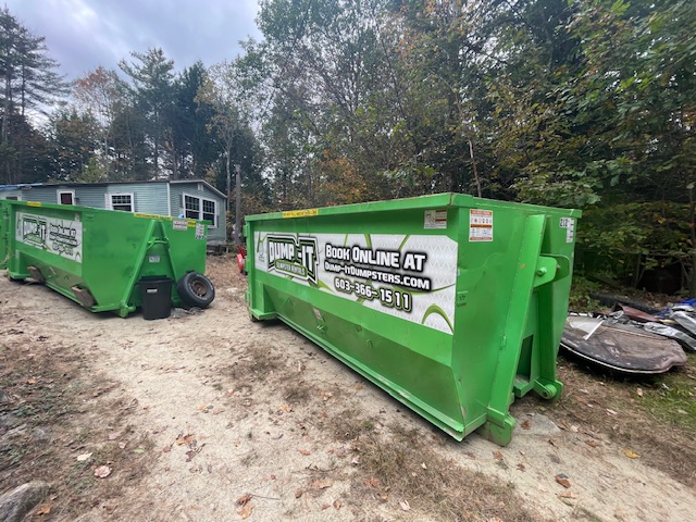 Dump-It Dumpster Rentals logo over a driveway dumpster at night.
