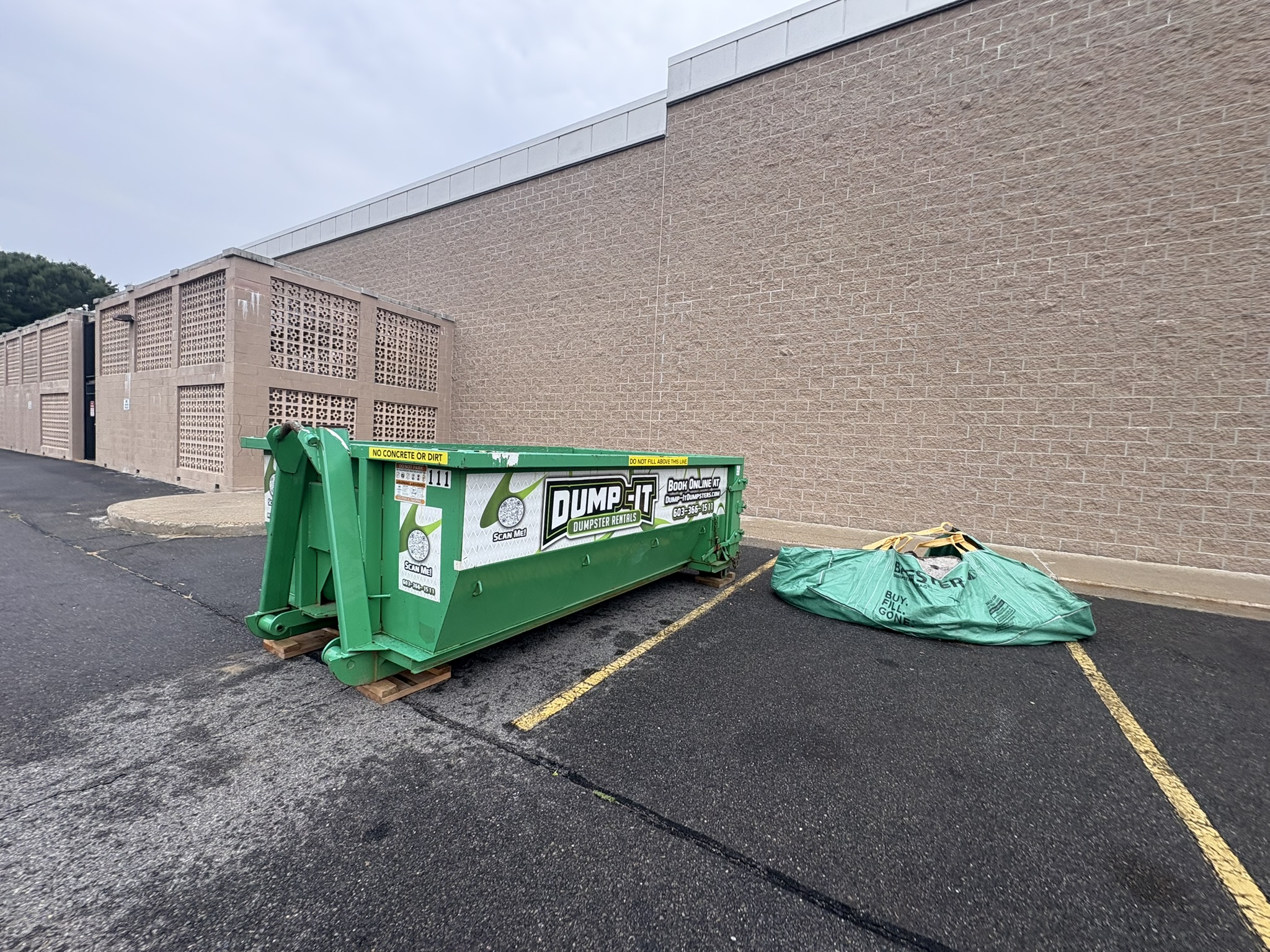 Dump-It Dumpster Rentals logo over a construction site