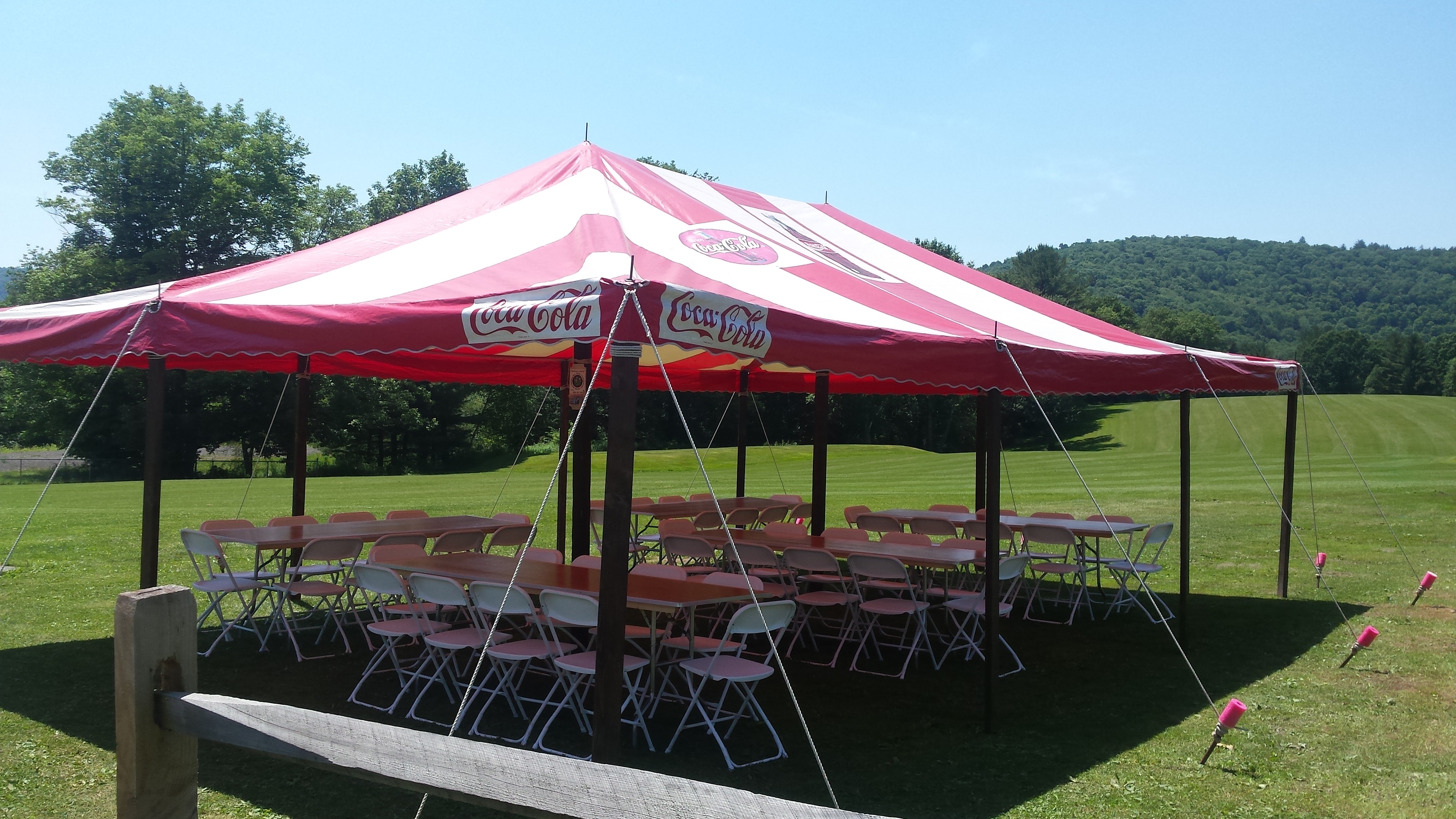 Party tent set-up with tables and chairs underneath Party tent set-up with tables and chairs underneath