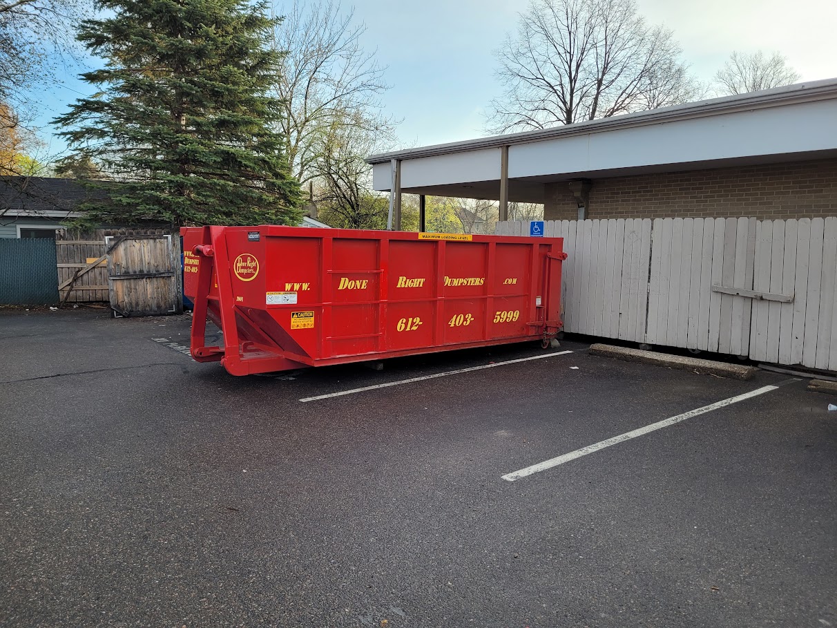Large red commercial dumpster from Done Right Dumpsters in a parking lot. Large red commercial dumpster from Done Right Dumpsters in a parking lot.