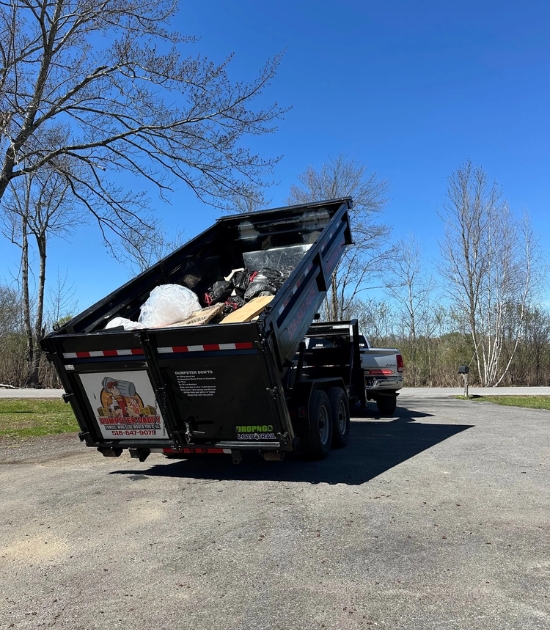 Dumpster Daddy dump trailer loaded with debris, showing reliable roll-off dumpster service in action