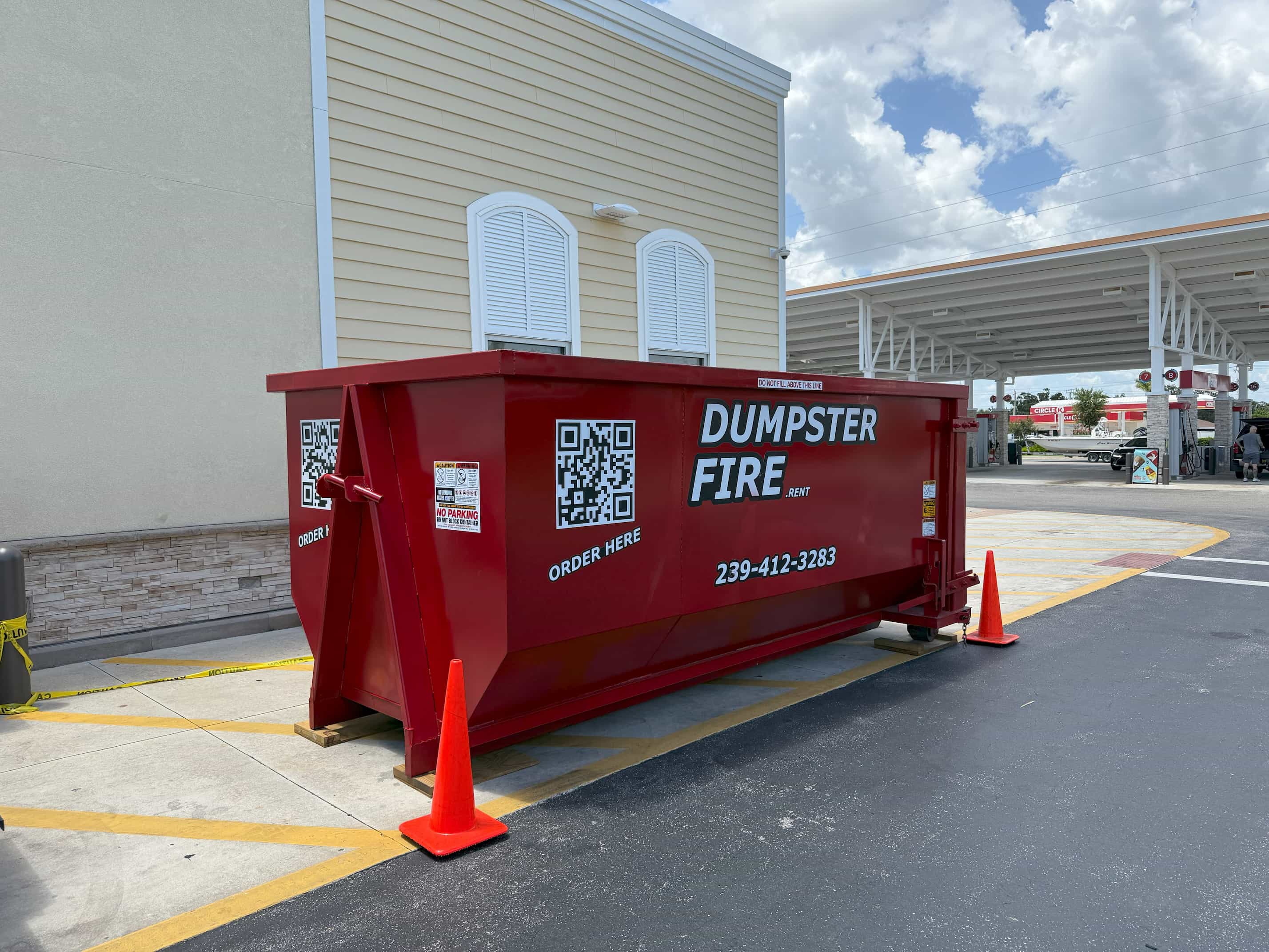Red Dumpster Fire rental bin in a driveway in Cape Coral, FLwith QR code