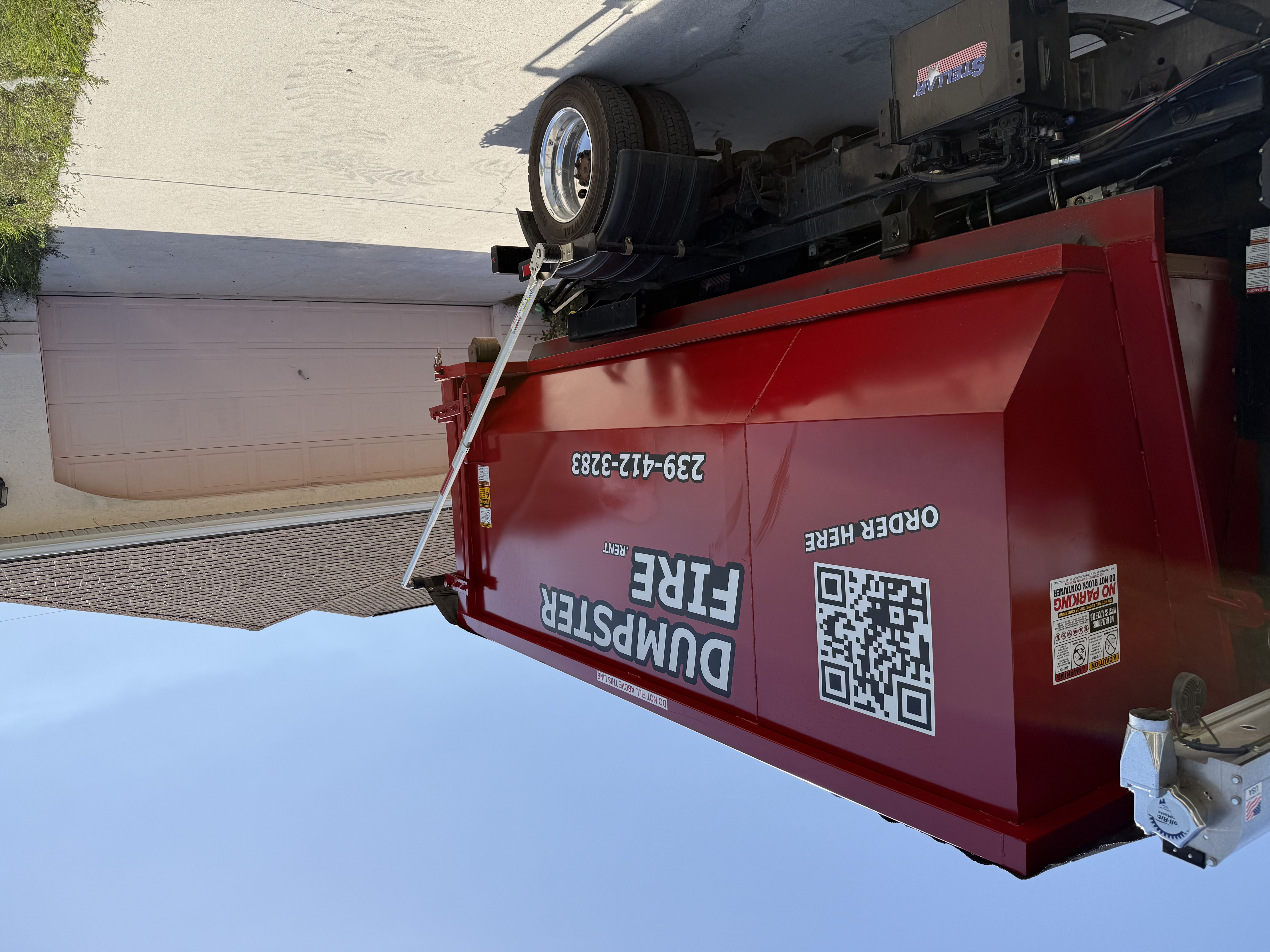 Dumpster Fire Rental red dumpster in residential driveway Dumpster Fire Rental red dumpster in residential driveway
