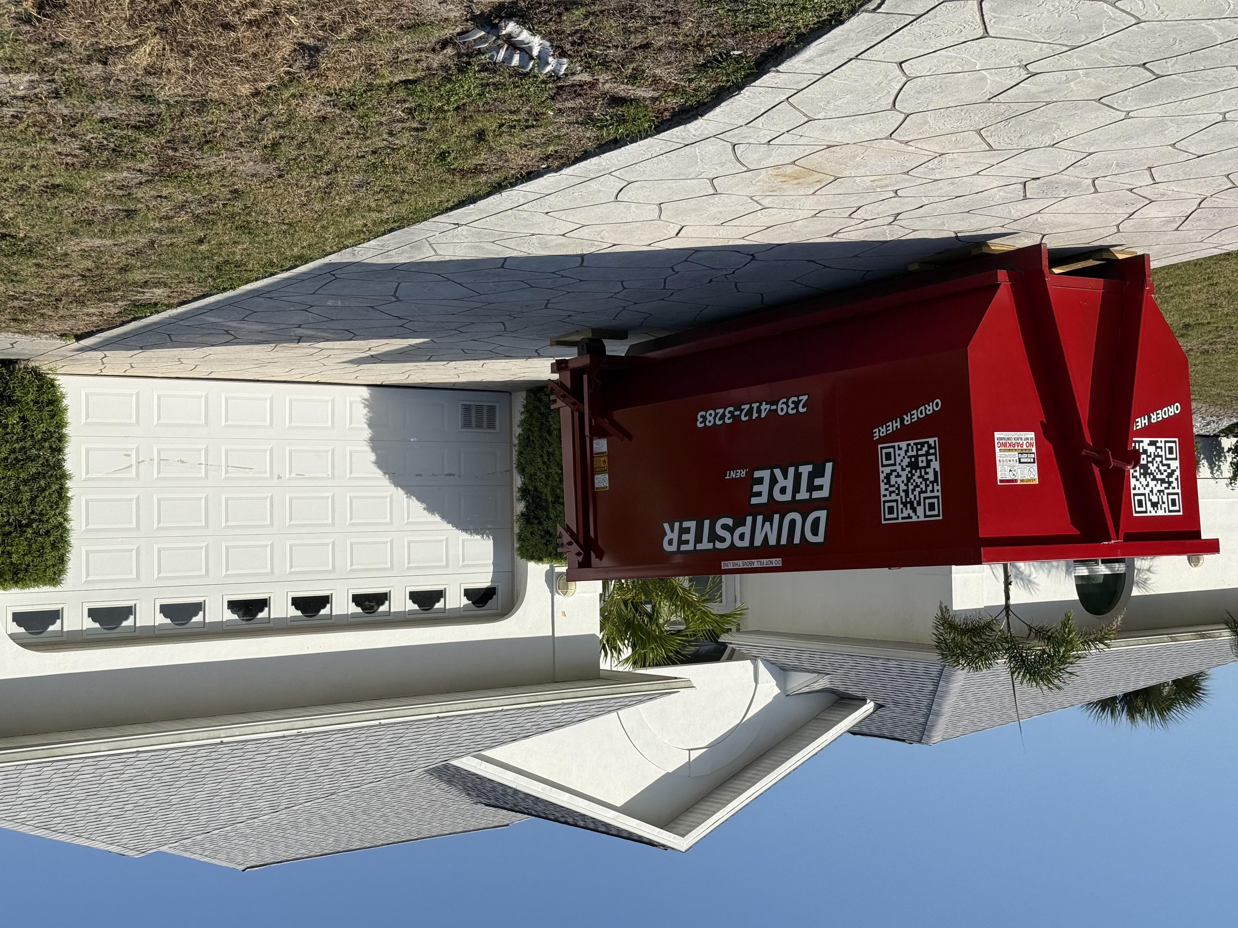 Red Dumpster Fire rental bin in front of a house Red Dumpster Fire rental bin in front of a house