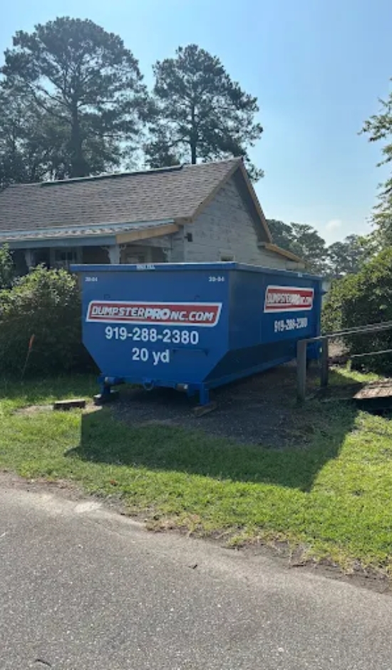 Blue 20-yard roll-off dumpster placed beside a residential home by Dumpster Pro NC