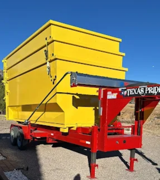 Yellow roll-off dumpsters loaded on a red trailer for delivery with Dutton Dumpsters