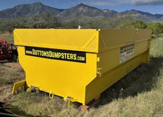 Yellow roll-off dumpster placed in a field from Dutton Dumpsters