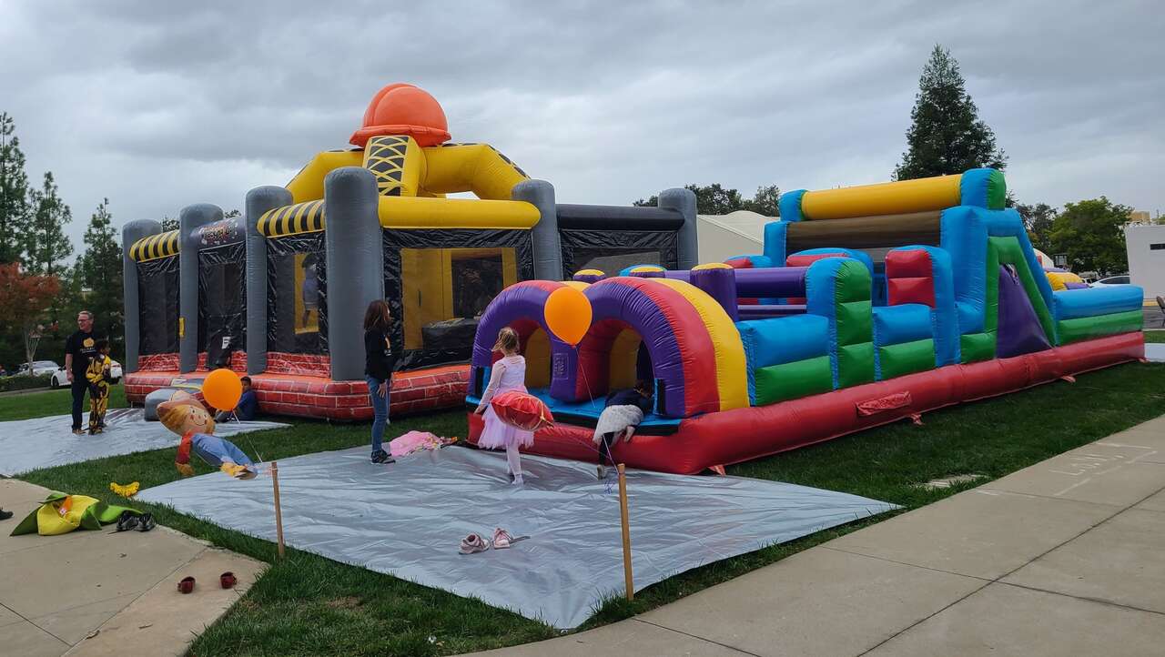Families enjoying inflatable rentals at Christ Community Church Harvest Festival in Carmichael