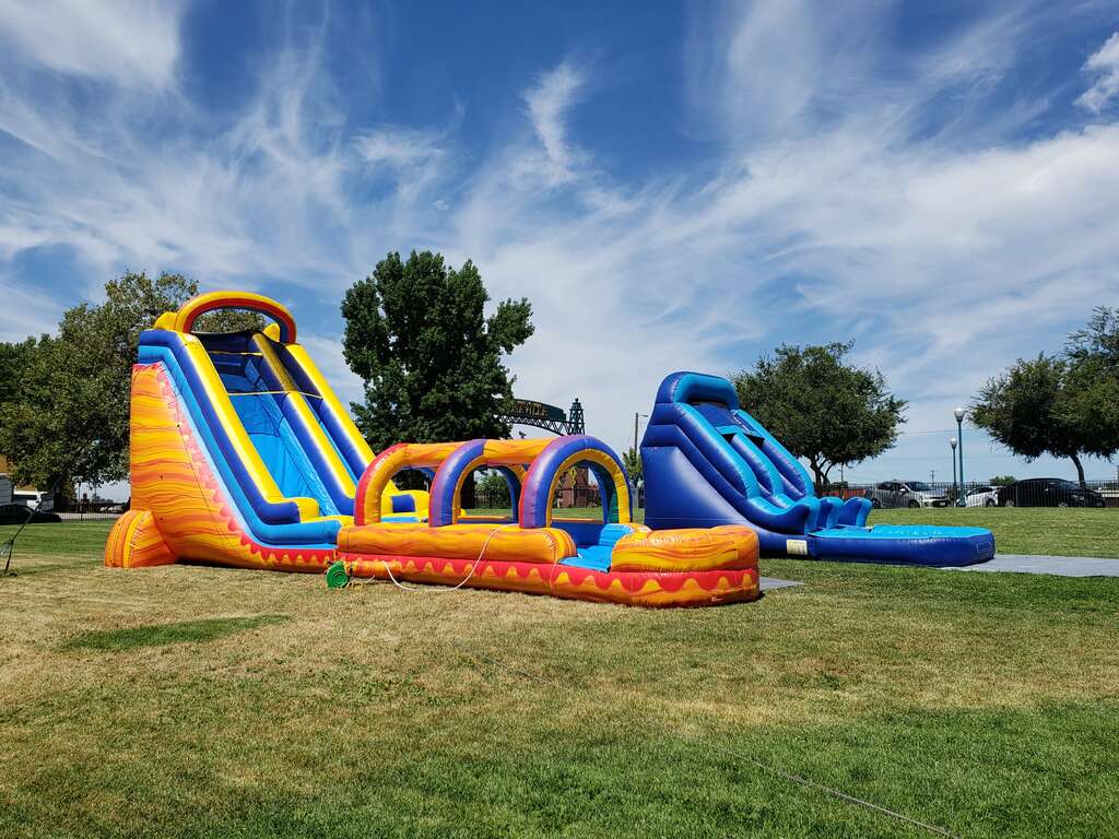 E&J Funday inflatable water slides professionally installed on grass for a large community event