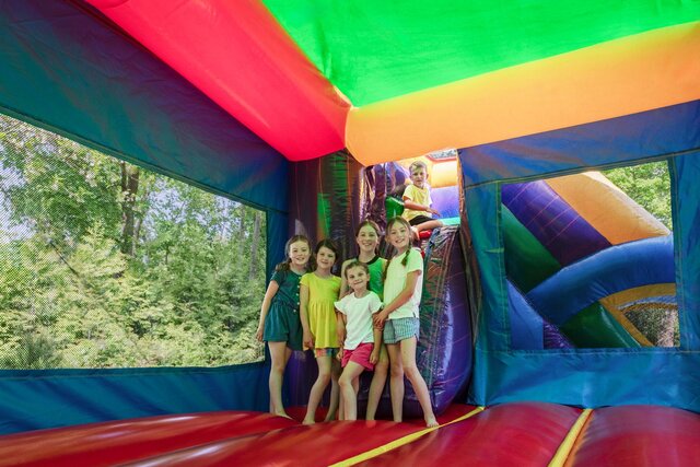 Kids playing inside a colorful Elite Event Rentals bounce house
