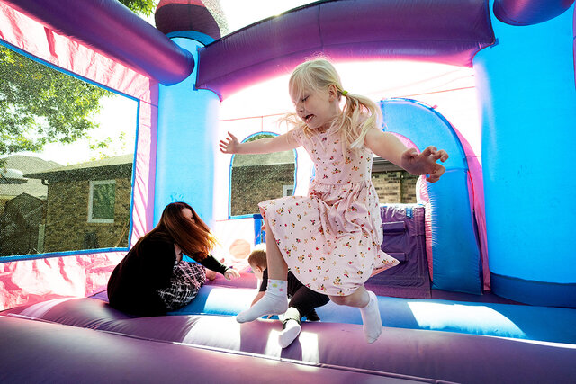 A mom and her child at a backyard party with an Elite Event Rentals inflatable
