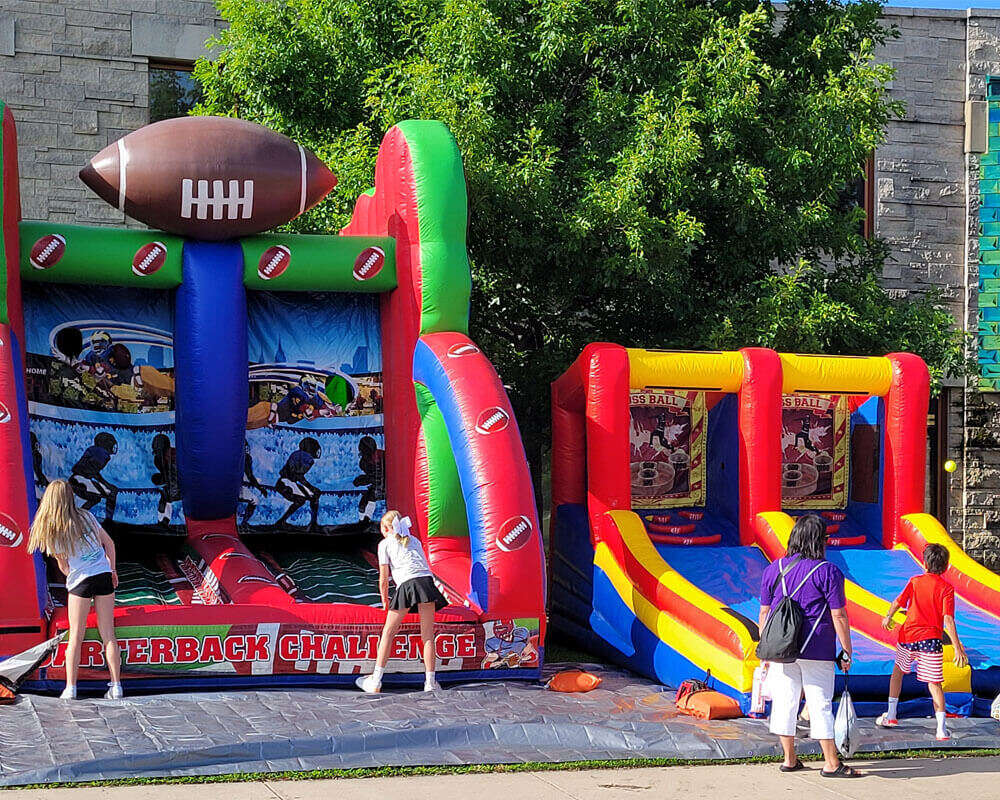 Kids playing on inflatable rentals at a real event setup