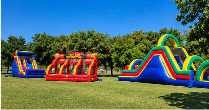 Water slide rentals and inflatable attractions set up for a city park event