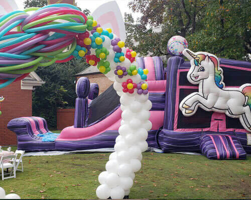 Decorated backyard celebration with a colorful combo bouncer