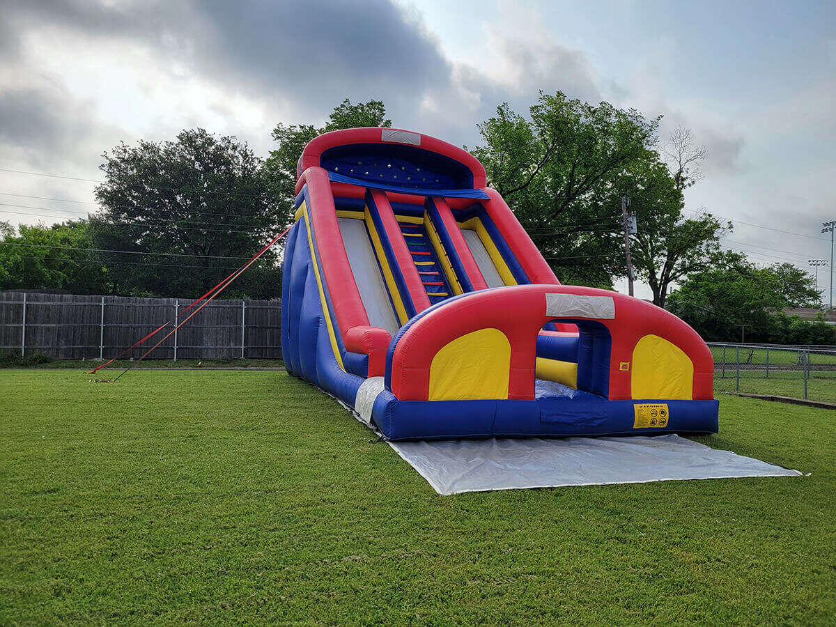 Large inflatable slide set up on a spacious lawn
