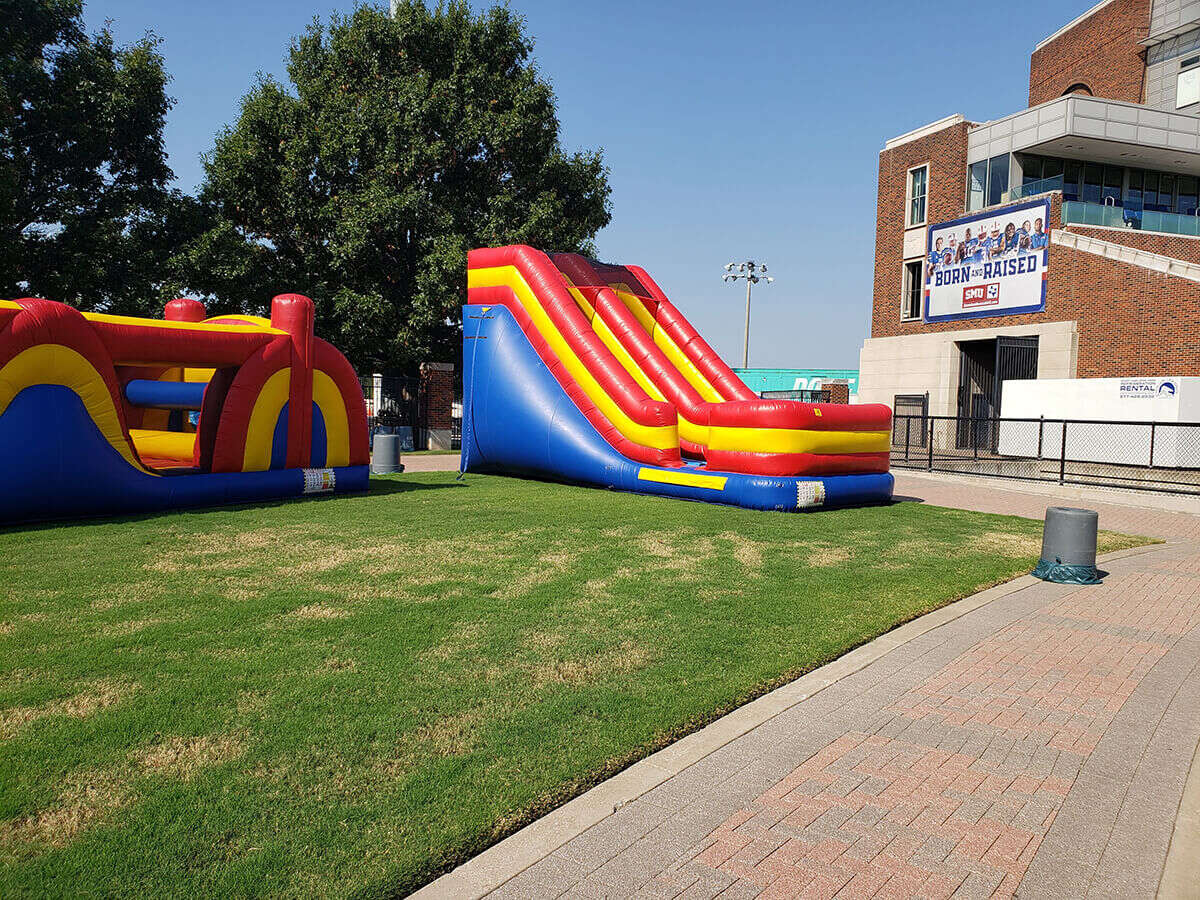 Kids enjoying inflatable attractions at an SMU game-day event