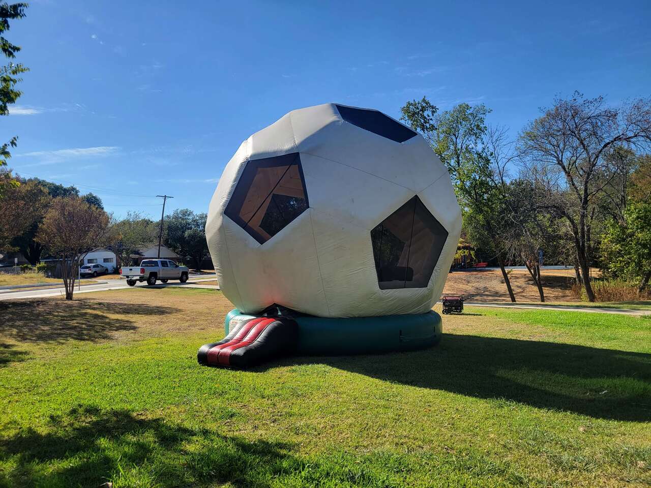 Large soccer ball themed inflatable set up on an open grassy area