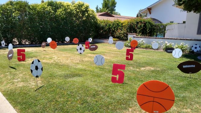 Birthday yard card disp[lay of big number 5s, soccer balls, baseballs and footballs nesr Avondale AZ