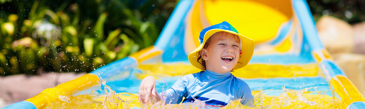 Kids playing on a water slide rental
