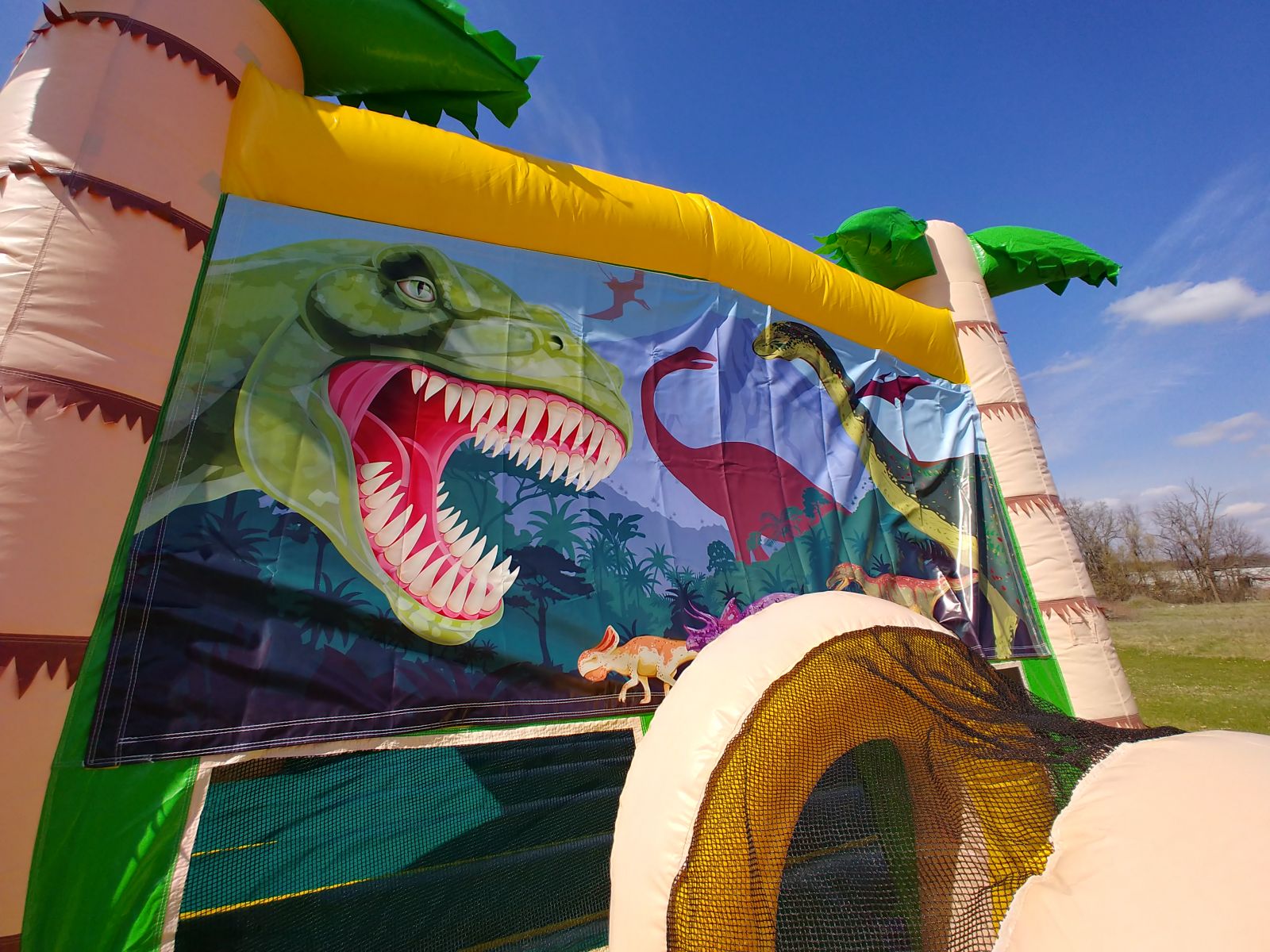 Dinosaurs on front of bouncy house for rent