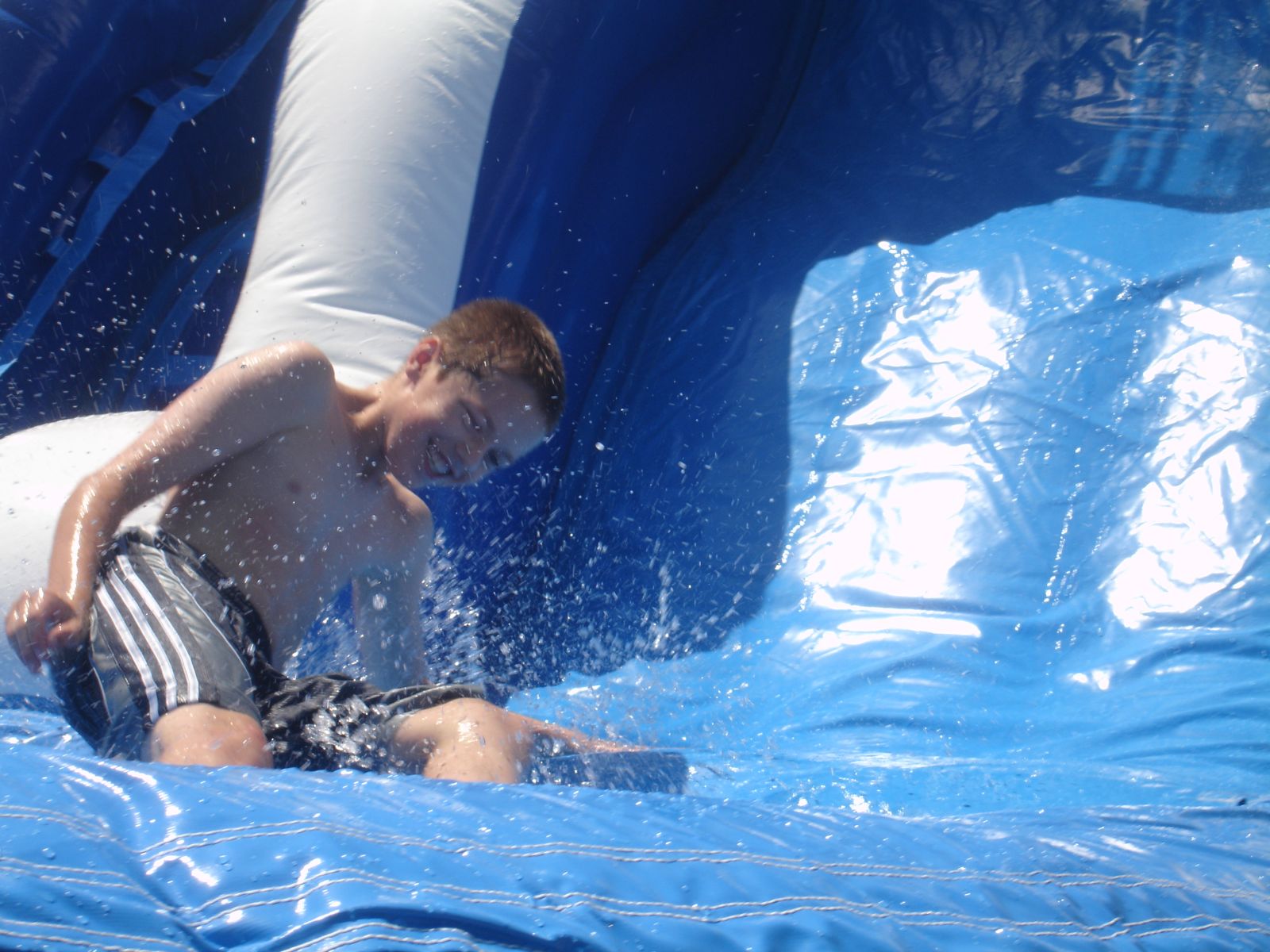 Boy splashing at bottom of the BIG Wave Water Slide Rental