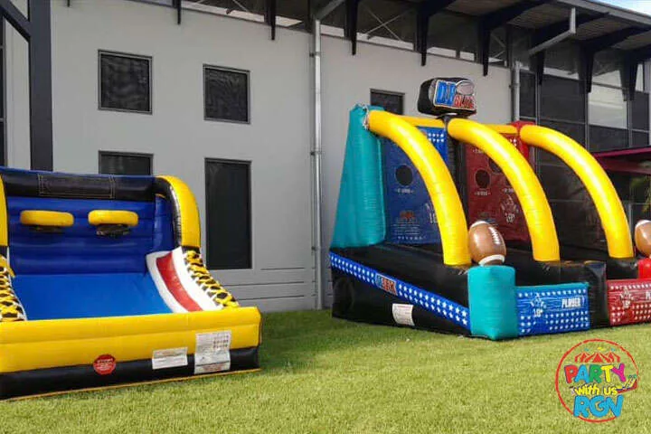 Bounce house and inflatable obstacle course set up outside an event building