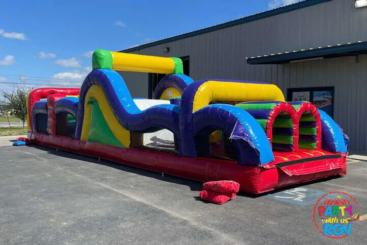 Colorful inflatable obstacle course with a slide outside an event venue