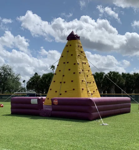 Yellow portable climbing wall set up on grass