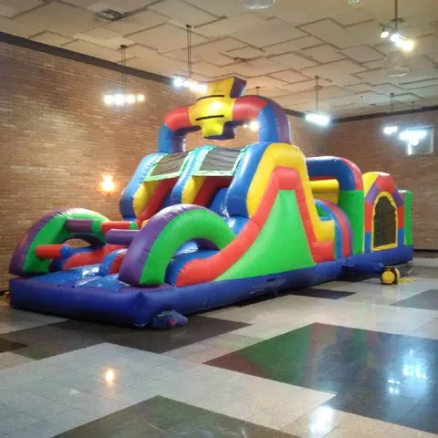 Colorful inflatable obstacle course with a slide inside a gym