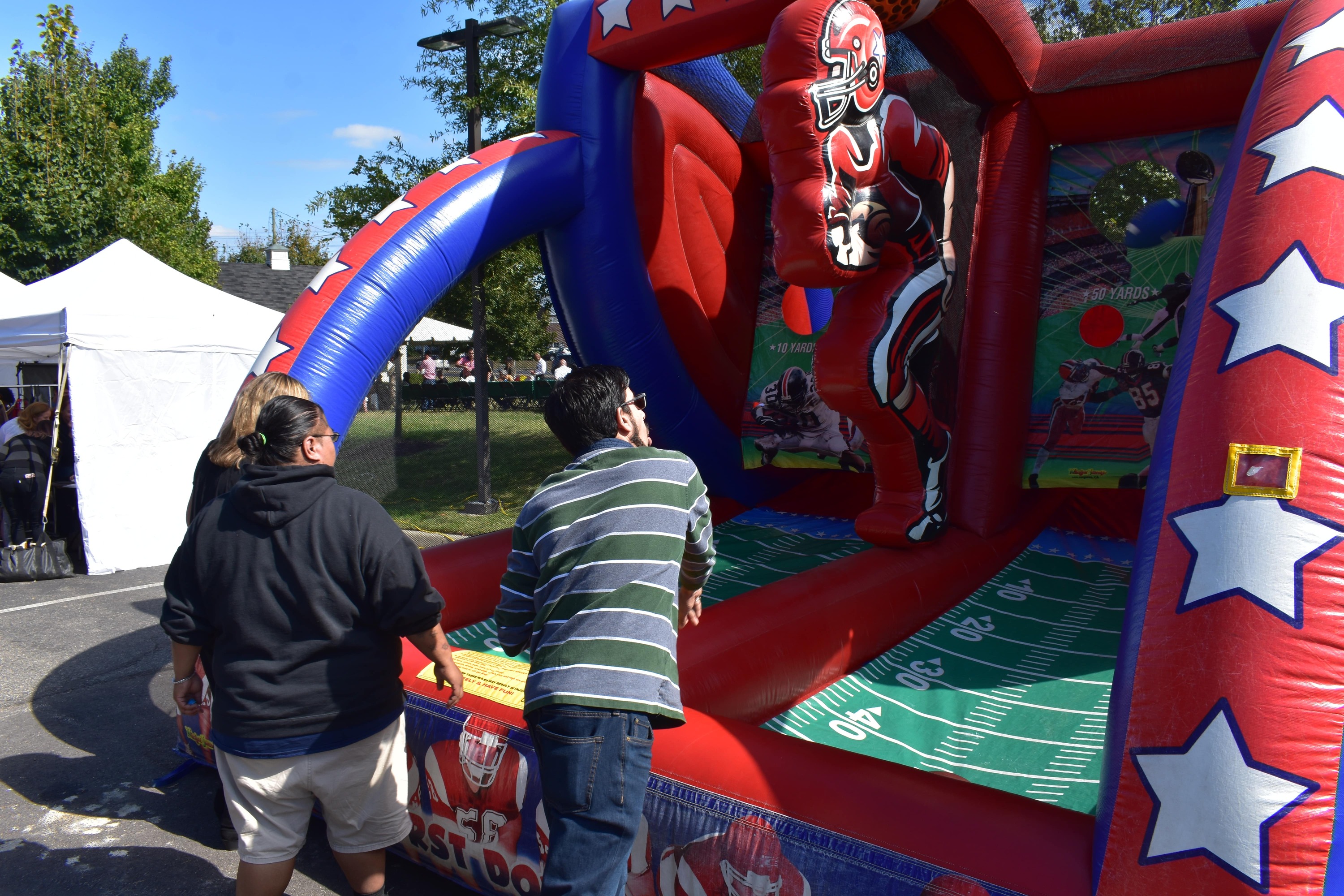 Boys playing in a football inflatable game with a scoreboard and vibrant graphics.