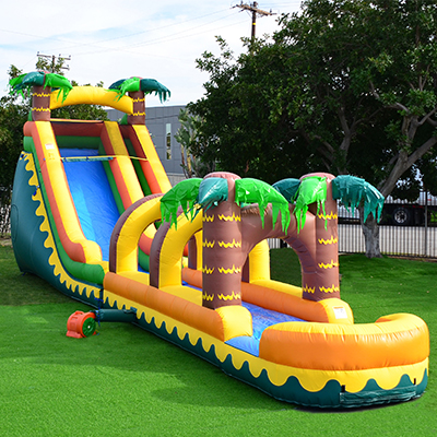 Inflatable water slide with palm trees on a sunny day.