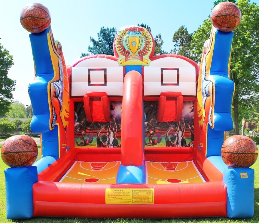 Close-up view of the Shooting Stars Basketball Shootout inflatable game, showcasing the detailed basketball court design on the base, the bright red shooting lanes, and the white backboards with netted hoops. The game is adorned with cartoon-style basketball player graphics on the side pillars, and the top is crowned with a colorful scoreboard graphic.