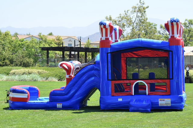 Knockout Combo bounce house set in a sunny park with boxing gloves