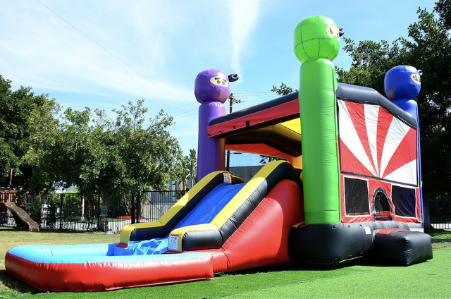 Outdoor inflatable ninja course with bright colors and playful ninja tops.