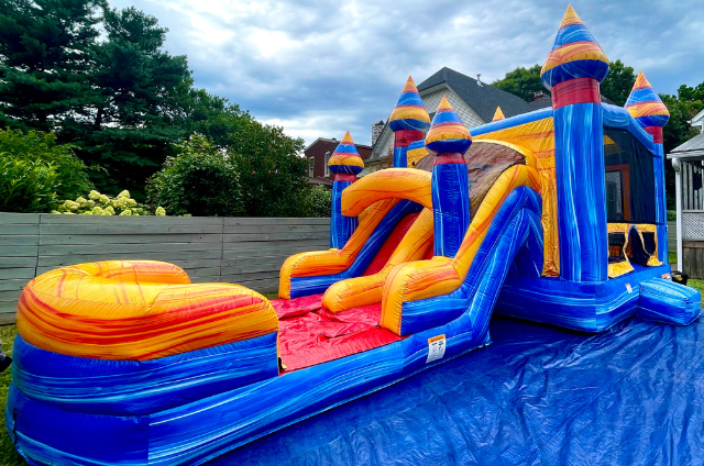 Vibrant Orange Crush Inflatable Combo set up in Louisville backyard with dual slides and castle peaks