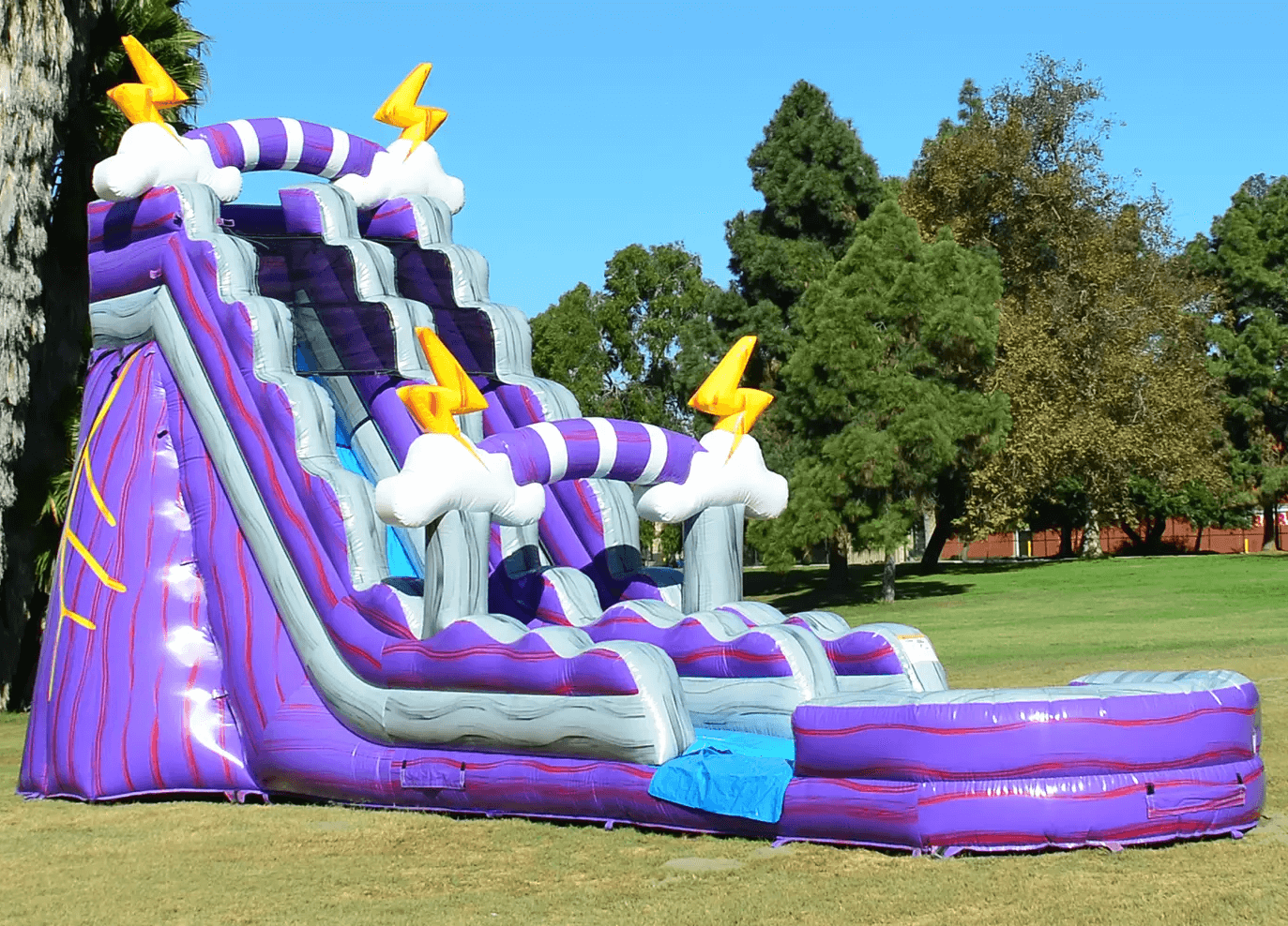 Thunder inflatable water slide rental in a green field.