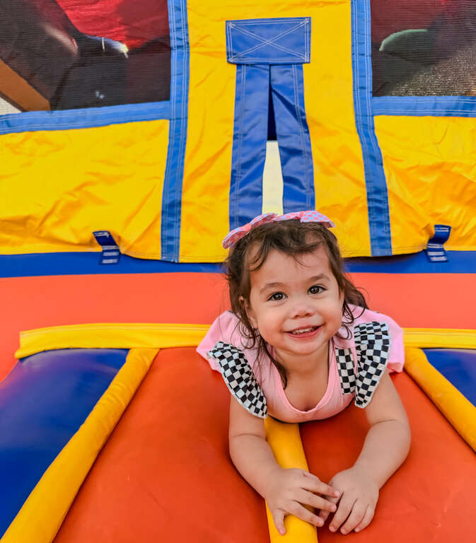 Happy child enjoying a bounce house rental at a backyard kids party in the West Valley