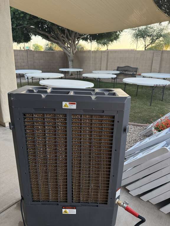 Commercial swamp cooler party rental keeping guests comfortable at a backyard event with tables and chairs in Goodyear Arizona