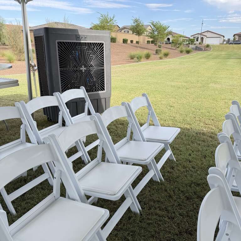 Commercial swamp cooler rental operating beside resin chairs at a corporate event under a 20x20 high peak tent.
