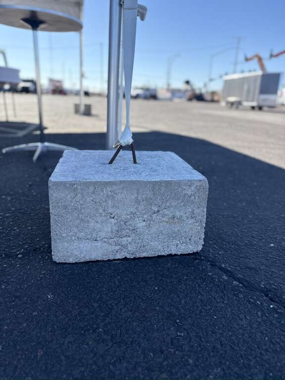 Concrete ballast block used to secure a tent rental on hard surfaces in Goodyear, AZ