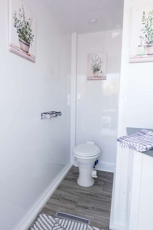 Wide bathroom trailer interior with private toilet and vanity