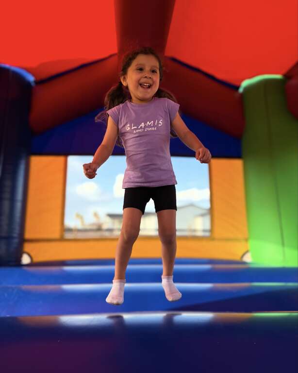 Kids jumping inside a bounce house rental at a backyard party in Goodyear, AZ