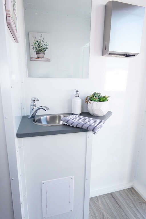 Luxury restroom trailer sink and mirror interior for backyard party restroom rental