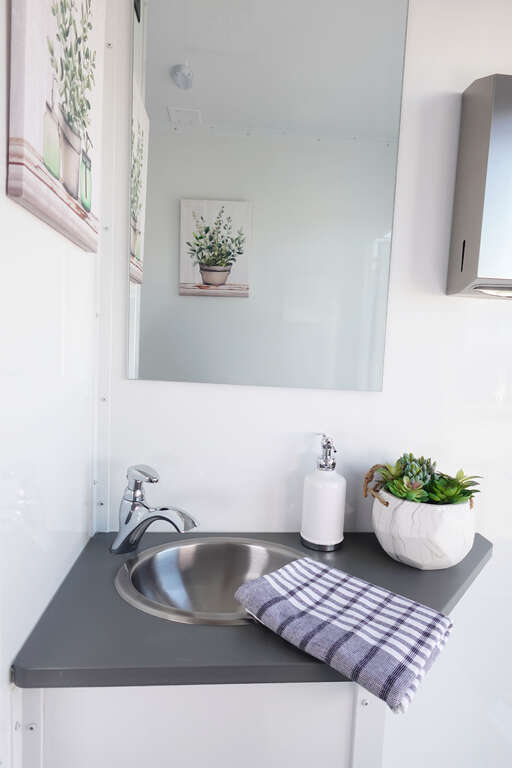 Luxury restroom trailer sink vanity with running water and mirror in Phoenix Arizona