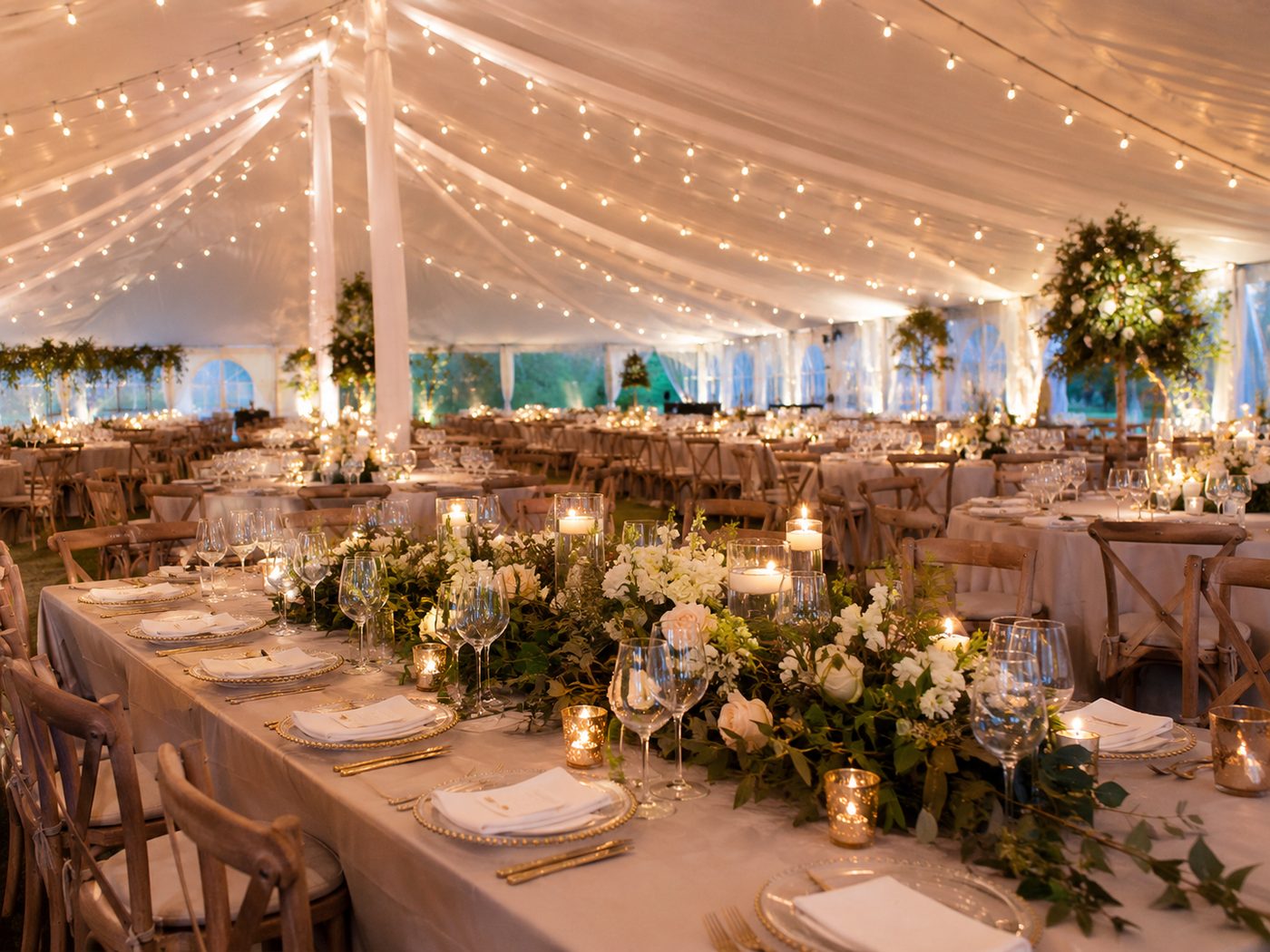 string lights and florals inside a wedding tent
