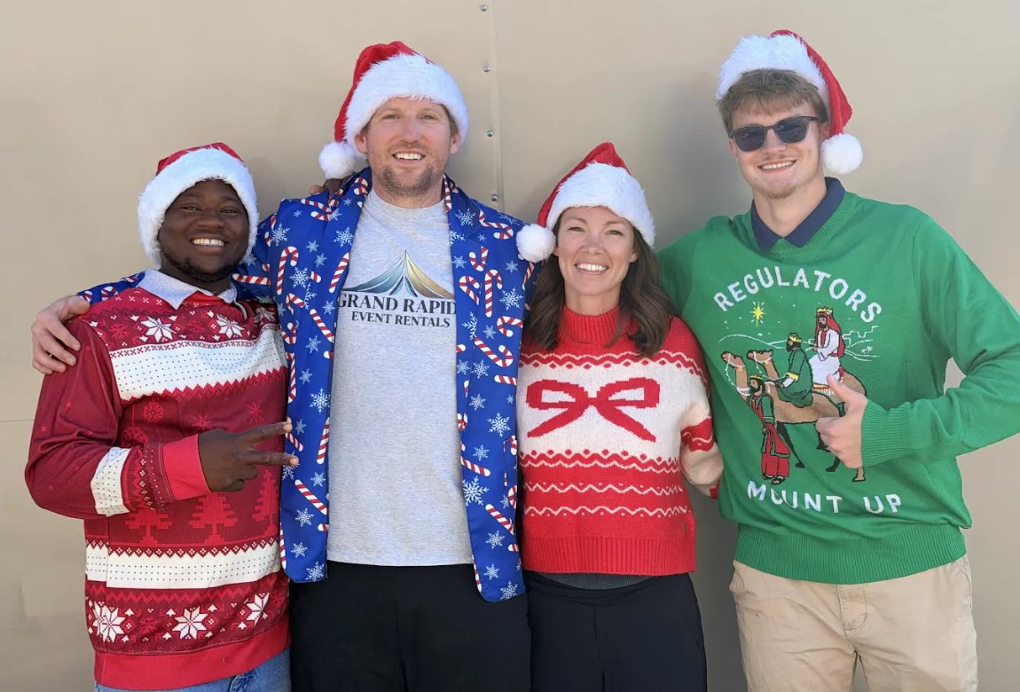 The Grand Rapids Bounce Houses Christmas light installation crew in holiday sweaters and Santa hats