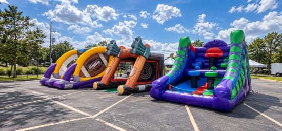 Colorful sports-themed inflatable games featuring football, basketball, and interactive challenges set up outdoors.