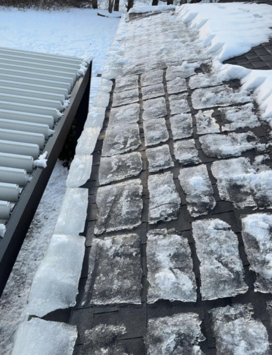 Thick frozen gutter ice requiring professional removal