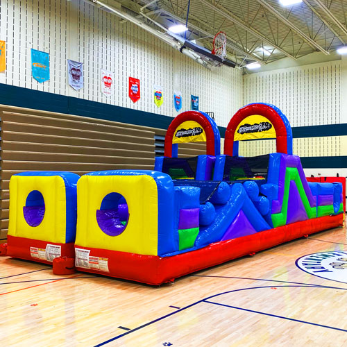 Large inflatable obstacle course set up at a corporate event
