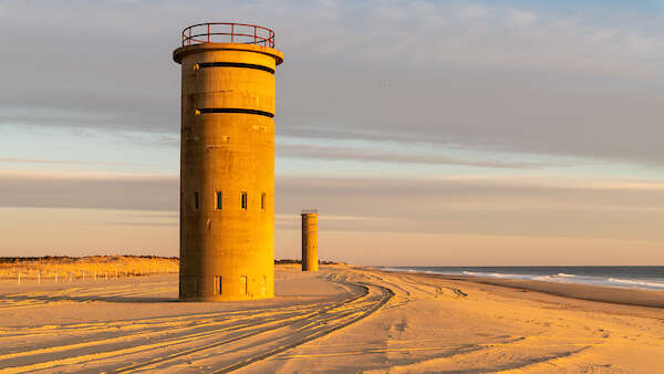 Observation towers along the beach at Cape Henlopen State Park during sunset.